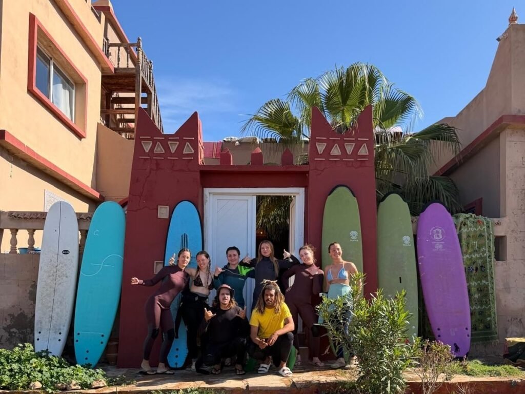 Guests with surfboards outside a surf house in Tamraght, Morocco